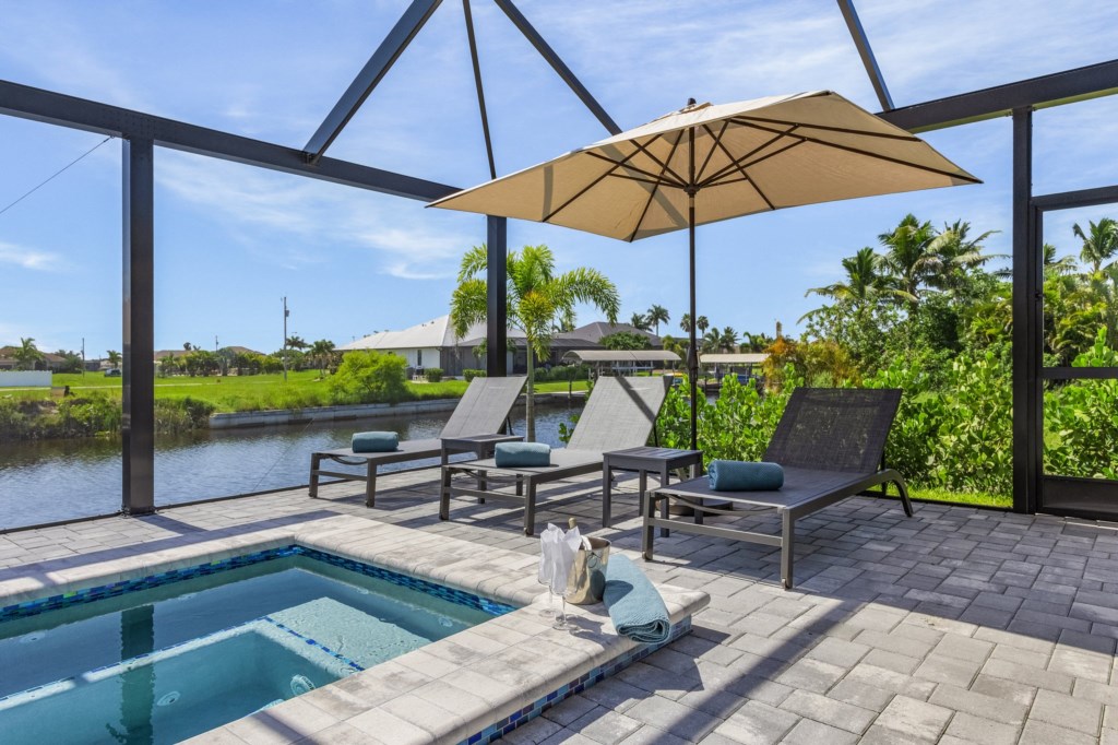 Relax in style by the pool with sun loungers, shaded seating, and beautiful canal views.