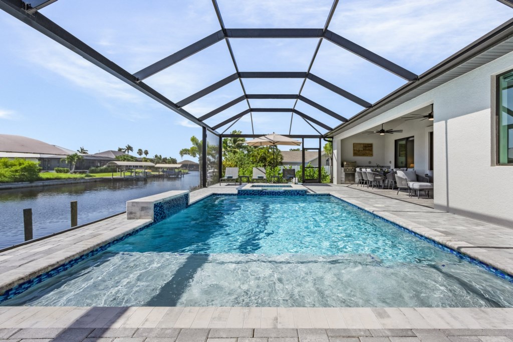 Spacious screened pool area with plenty of seating and a serene canal backdrop.