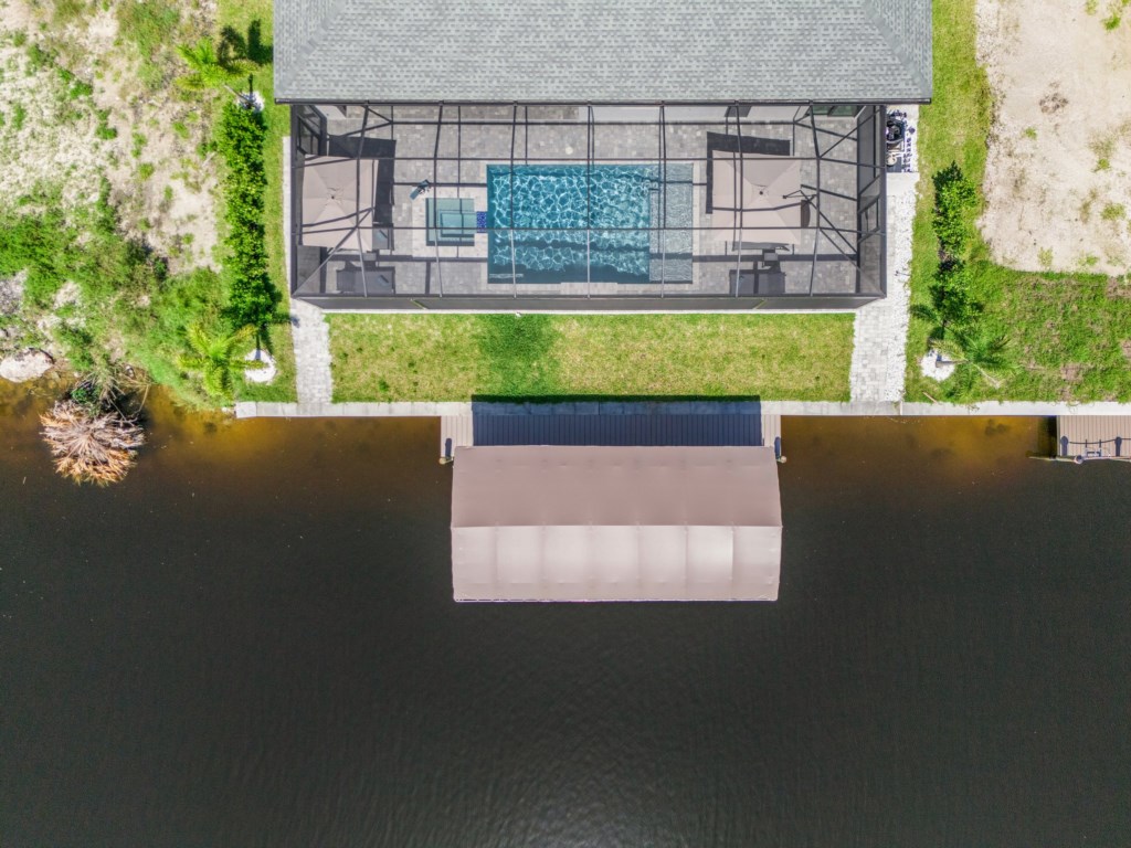 Stunning aerial shot of the pool and private dock along the canal, perfect for water enthusiasts.