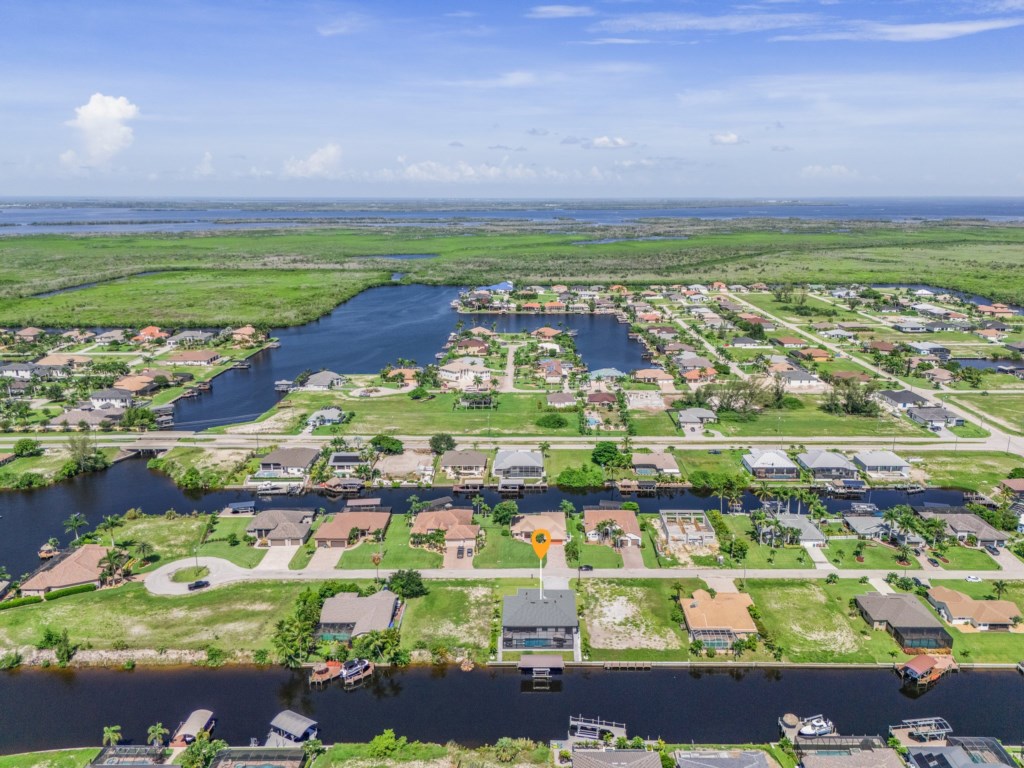 Breathtaking aerial perspective of the waterfront community surrounded by lush greenery and canals.