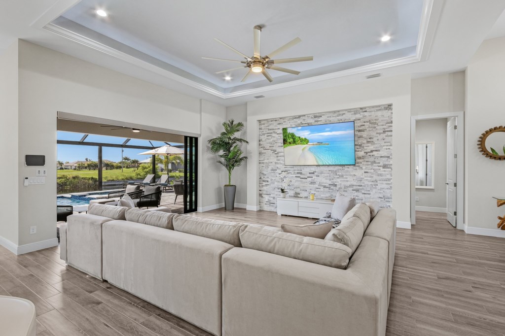 Bright, airy living room with cozy seating and large TV, perfect for relaxation.