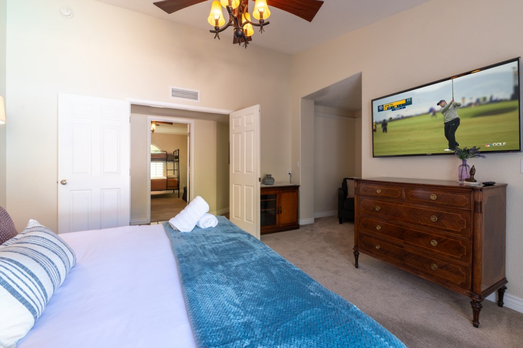 Cozy bedroom with a flat-screen TV and elegant wooden dresser for a relaxing stay.