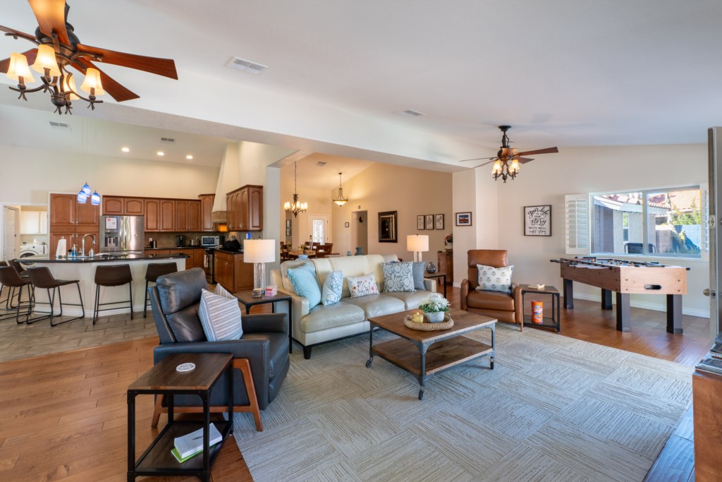 Spacious open-concept living area with cozy seating and foosball table for entertainment.