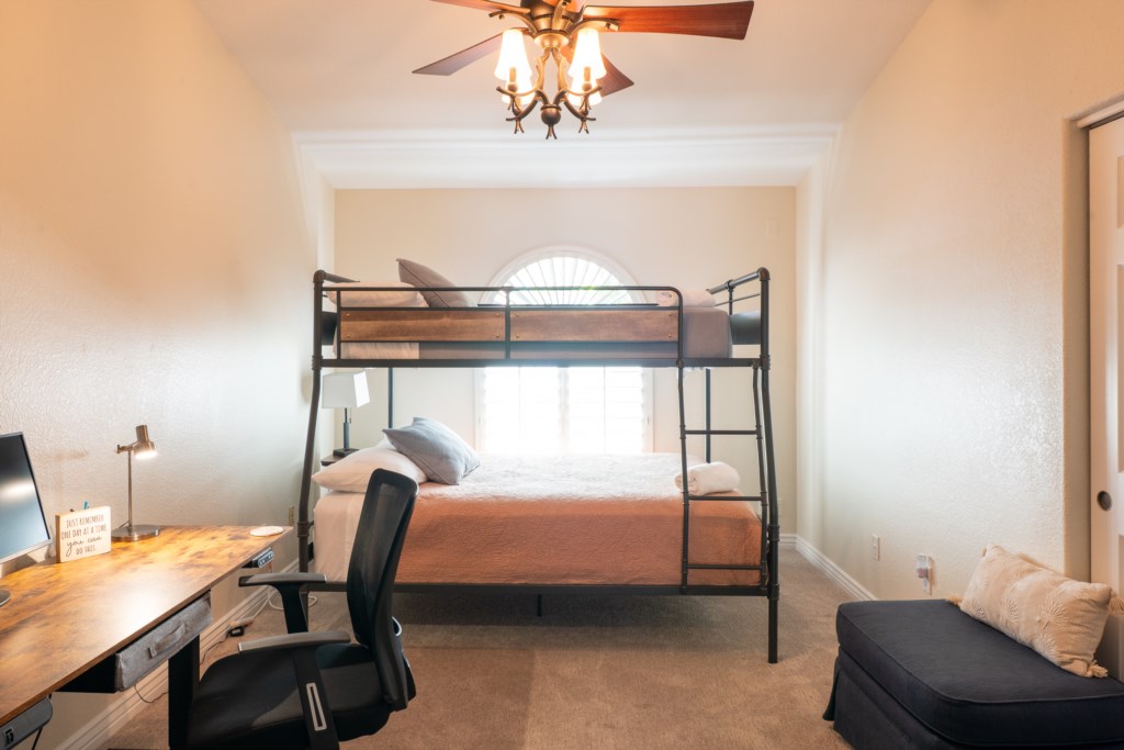 Cozy bedroom with bunk beds and a workspace, perfect for families or remote work.