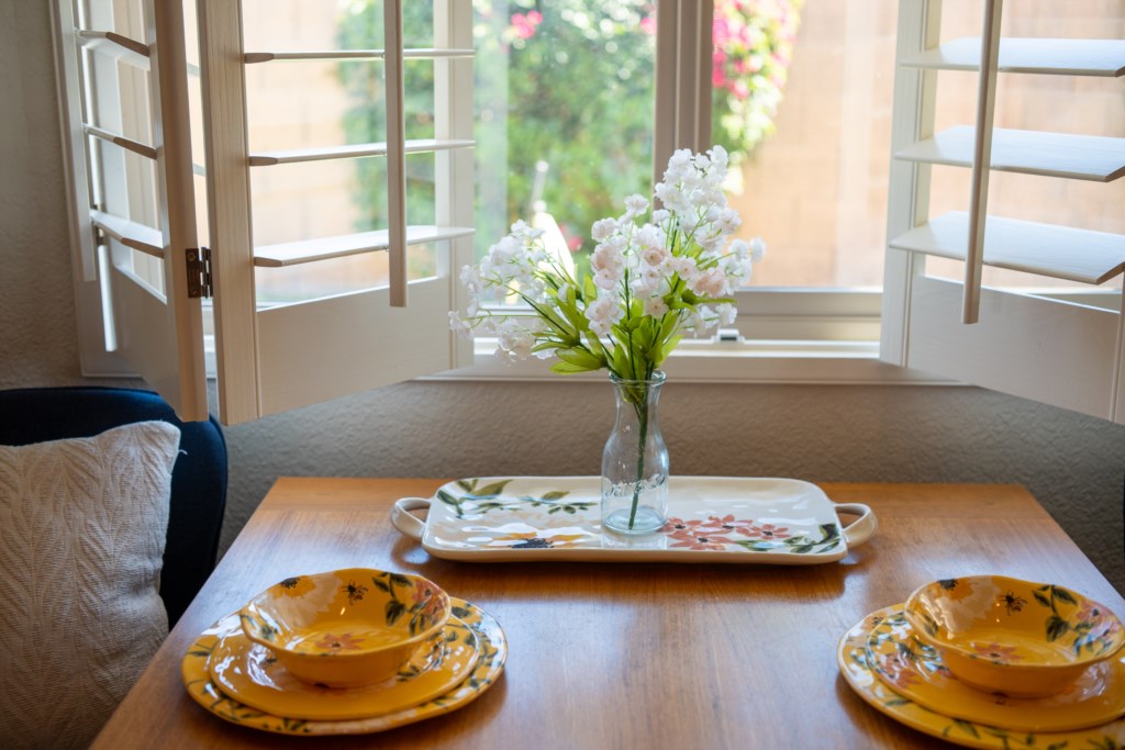 Charming breakfast nook with floral dishware and natural light.