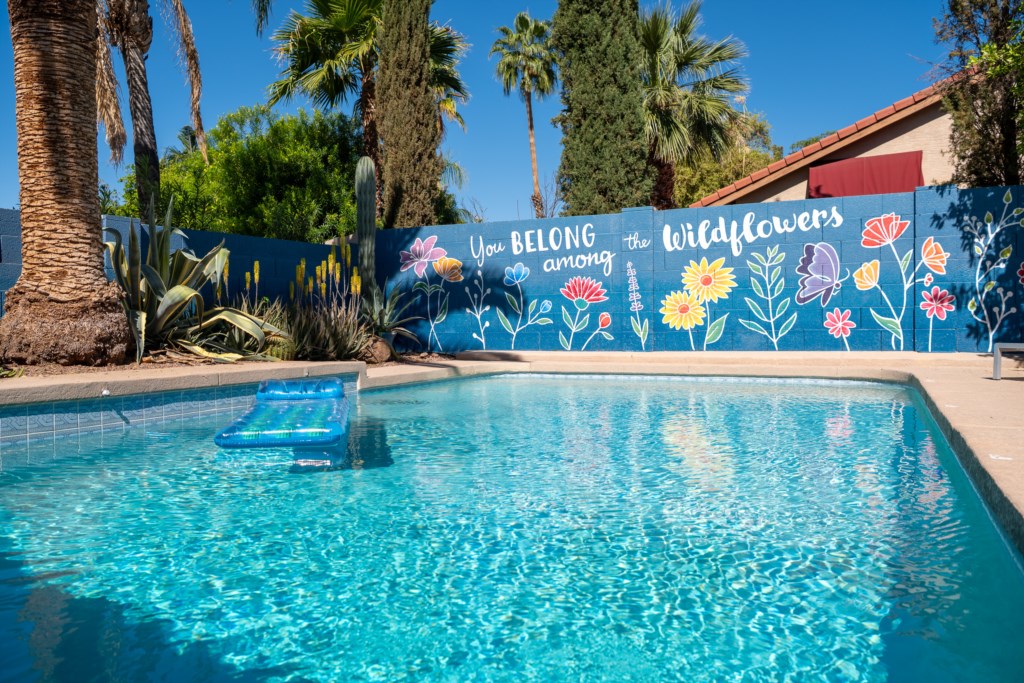Relax by the vibrant pool with floral mural and enjoy tranquil, sunny days.