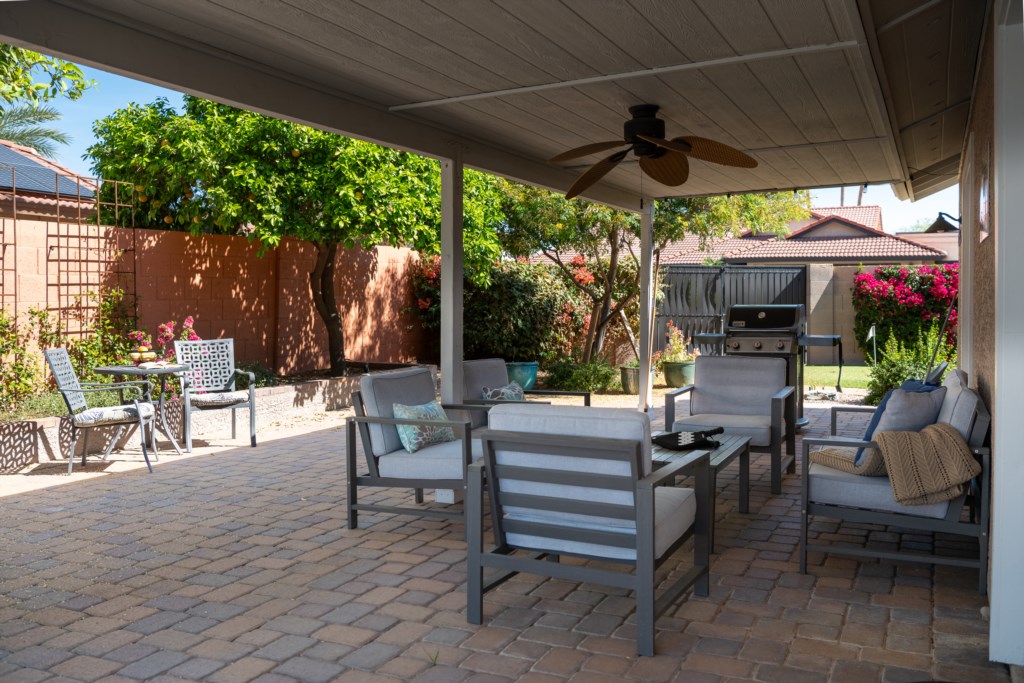 Covered patio with cozy seating and BBQ grill, perfect for outdoor gatherings.