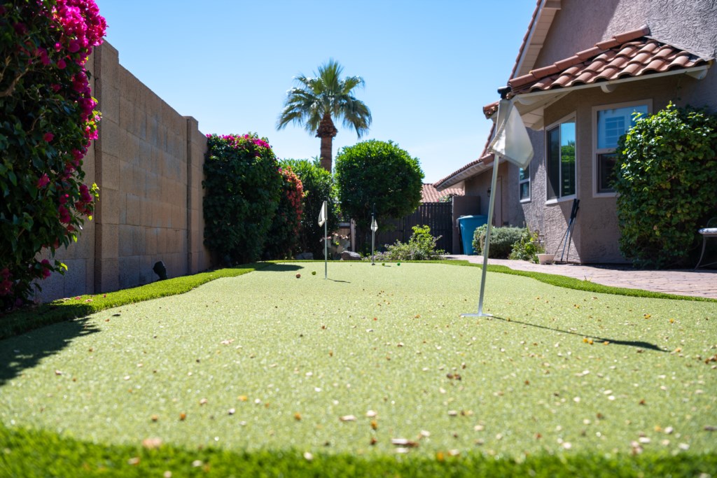 Private backyard putting green for relaxing golf practice under sunny skies.