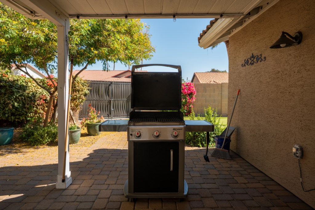 Covered patio with a grill, perfect for outdoor barbecues and gatherings.