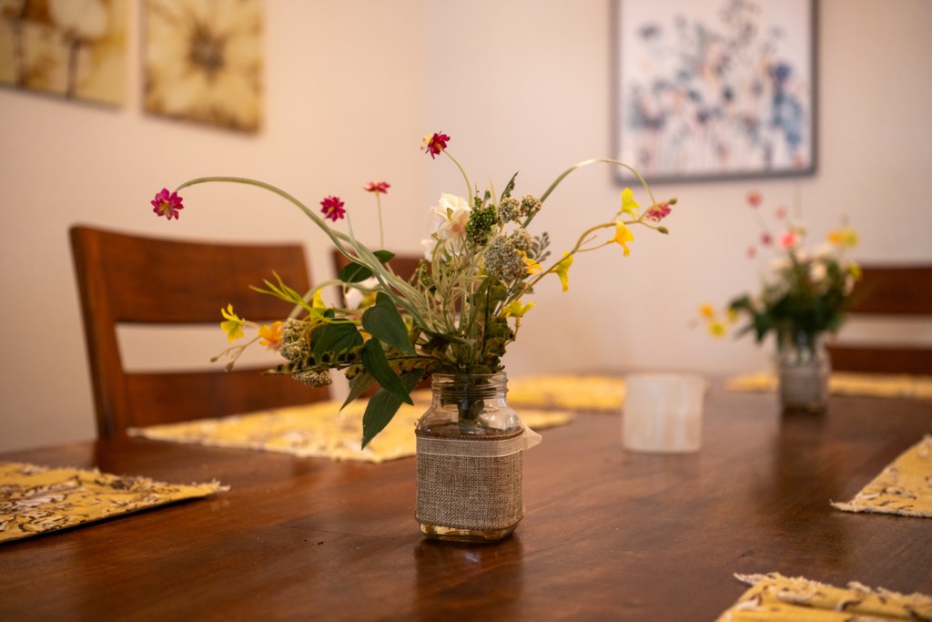 Charming dining area with rustic table and fresh floral centerpieces.