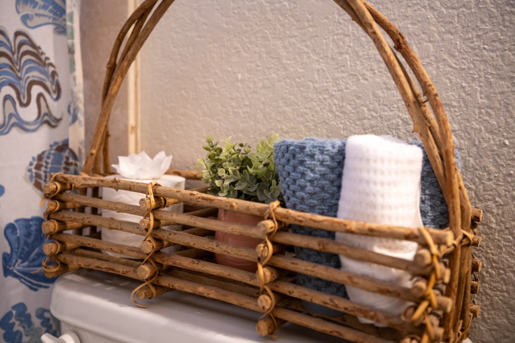 Charming bathroom decor with a rustic basket holding towels and essentials.