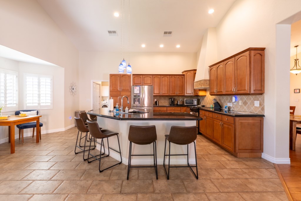 Spacious kitchen with modern appliances and breakfast bar seating, perfect for family gatherings.