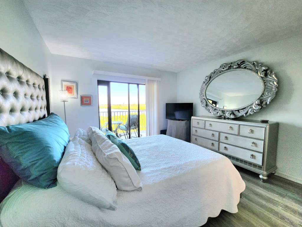Bedroom With Balcony access and waterfront views