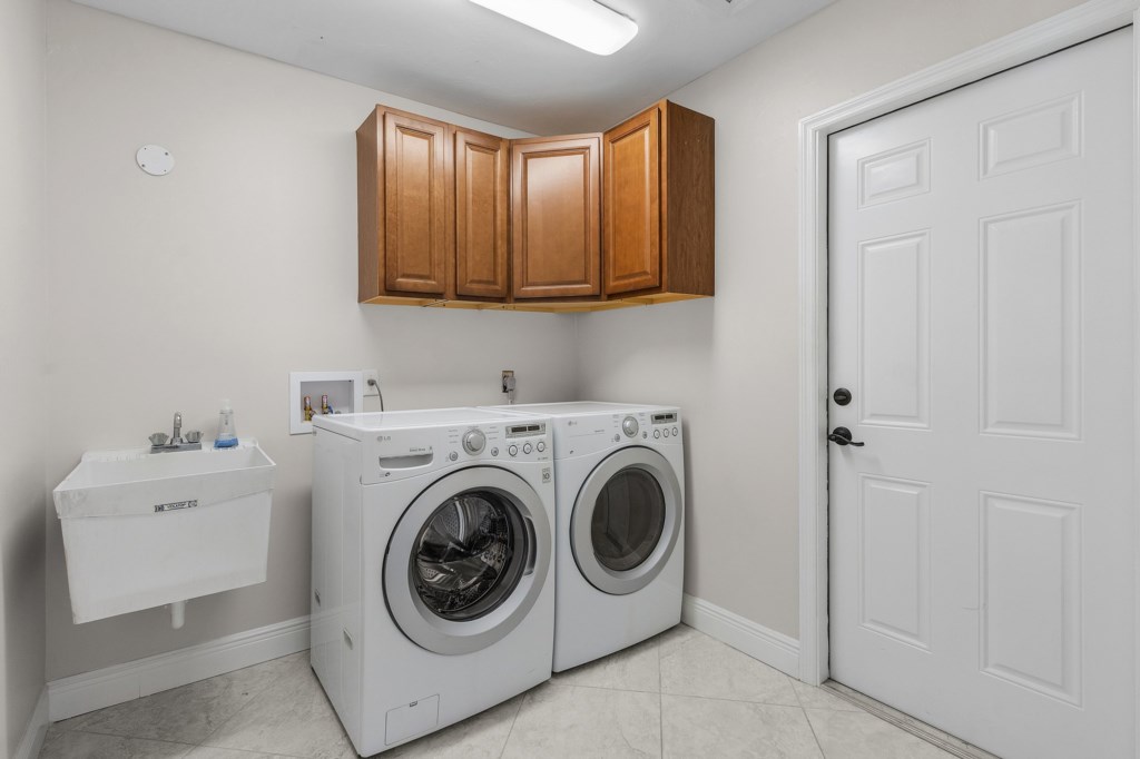 Convenient laundry room with washer, dryer, and storage space for your convenience.