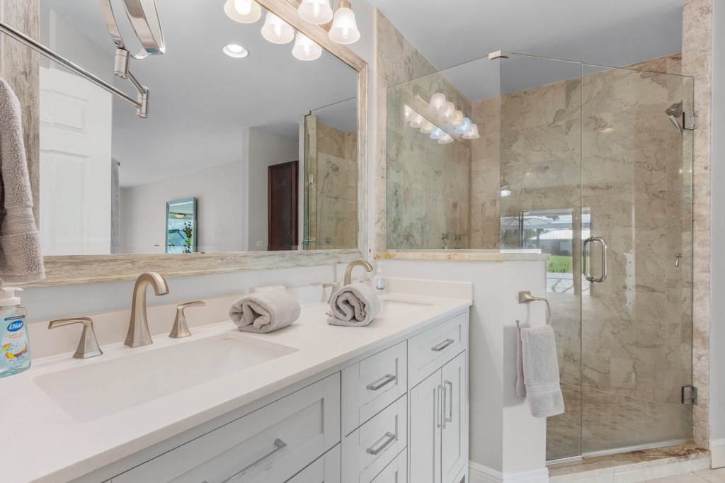 Luxurious bathroom with double vanity and spacious glass-enclosed shower.