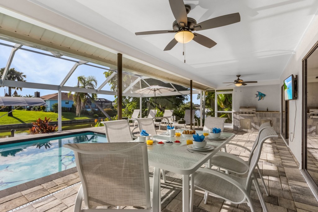 Enjoy al fresco dining by the pool in a beautiful screened-in patio.