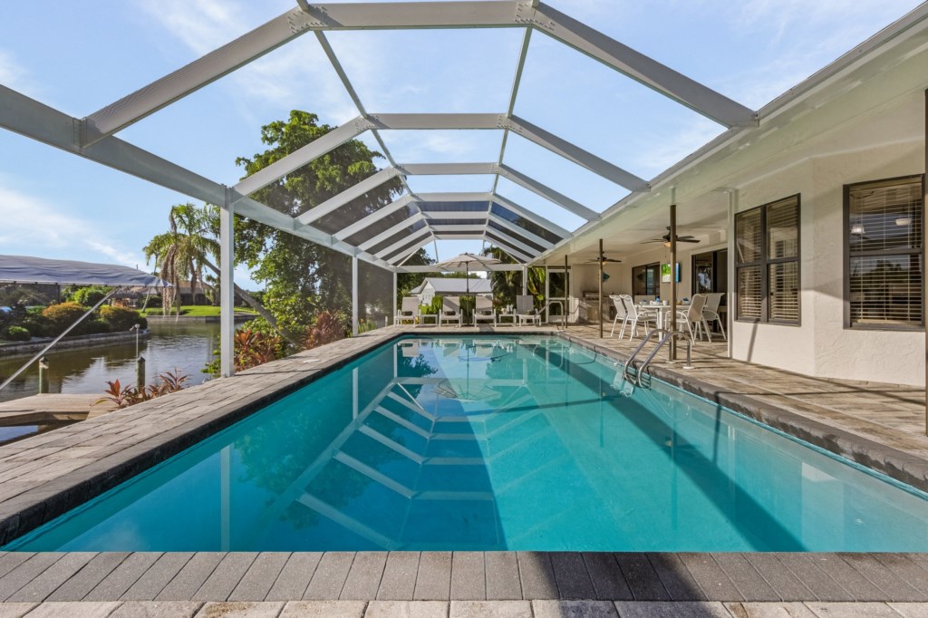 Take a refreshing dip in the expansive screened-in pool with scenic surroundings.