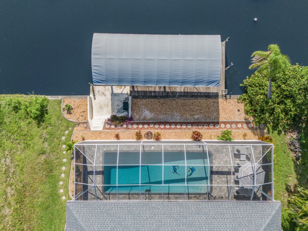 Aerial view of the screened-in pool, dock, and private boat access to the canal.