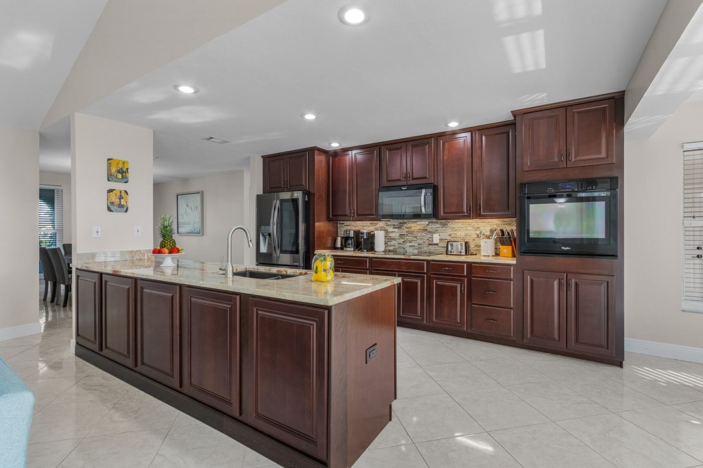 Fully equipped kitchen with elegant dark wood cabinetry and modern appliances for your cooking needs.