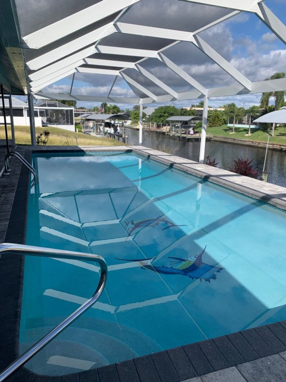 Relax by the private pool with serene canal views under the screened lanai.