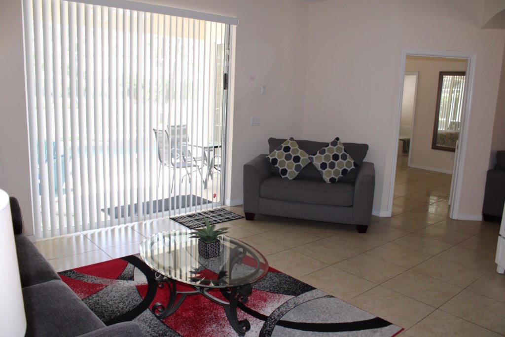 Spacious family room featuring direct access to the private covered pool lanai and outdoor patio area.