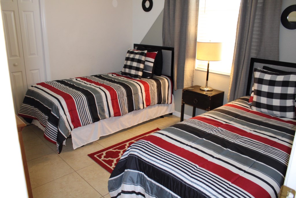 Bright and airy twin bedroom featuring two comfortable beds, bedside lighting, and a spacious closet 