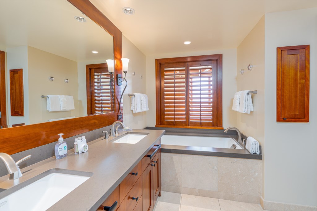 Primary bathroom with double sinks and a deep soaking tub.