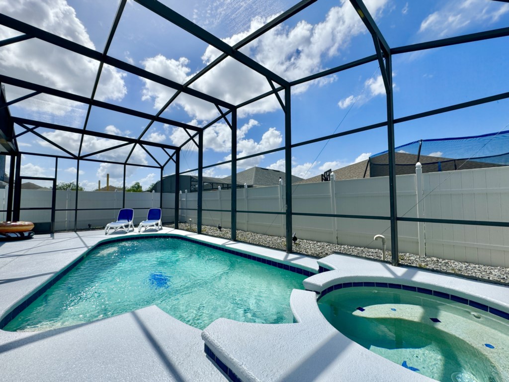 Relax by the private pool and hot tub in this screened-in backyard oasis.