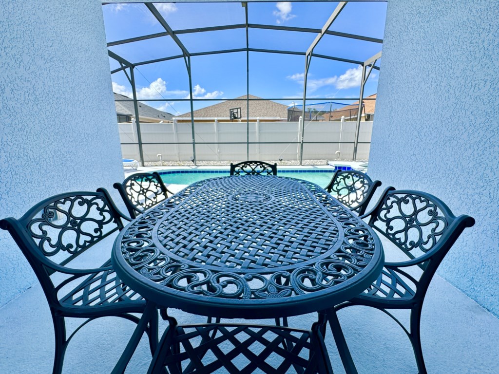 Outdoor dining space by the pool, ideal for enjoying meals under the sun.