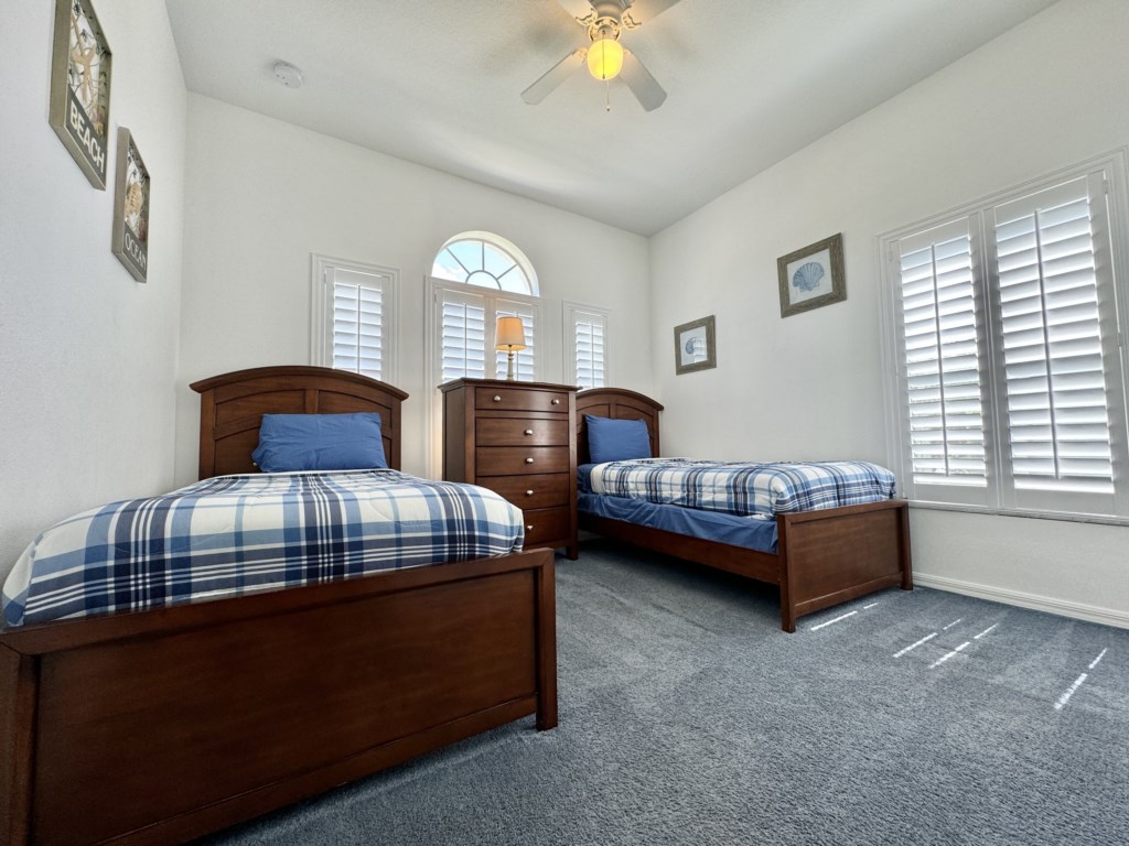 Cozy twin bedroom with natural light, perfect for kids or guests.