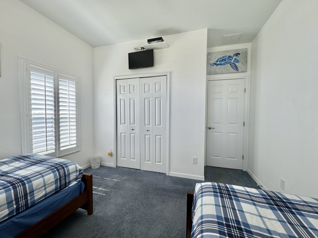 Twin bedroom with ample storage and a TV for entertainment.