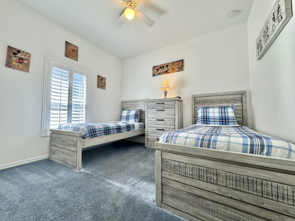 Bright and inviting twin bedroom with plenty of natural light and cozy bedding.