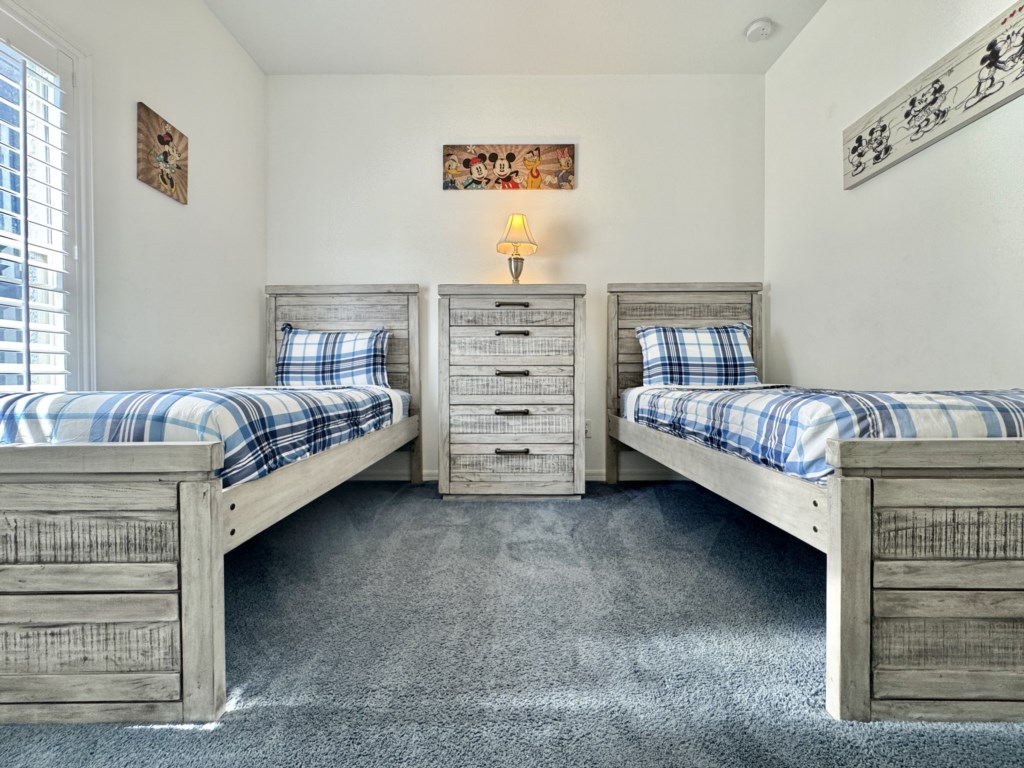 Spacious twin bedroom with stylish decor, perfect for a peaceful stay.