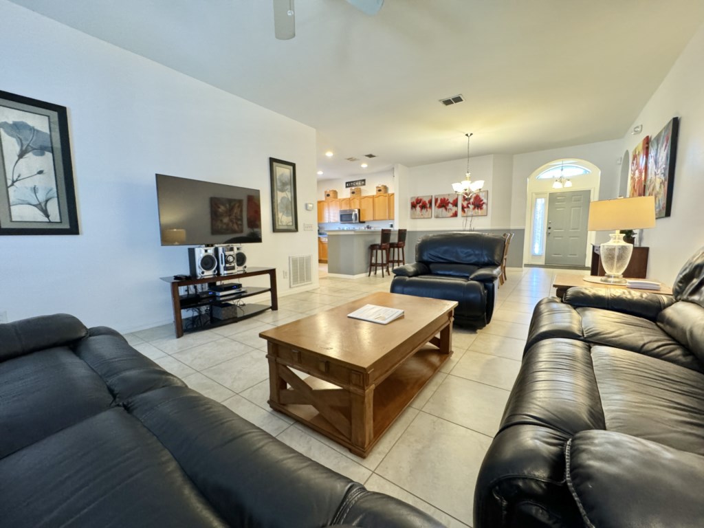 Spacious living room with large TV and comfortable seating for movie nights.