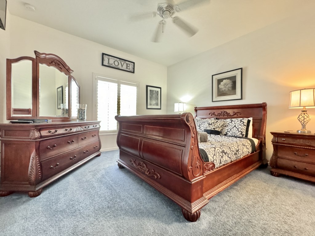 Elegant master bedroom with a luxurious wooden bed and serene ambiance.