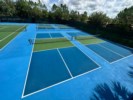 Freshly maintained tennis courts under sunny skies, perfect for an active outing.