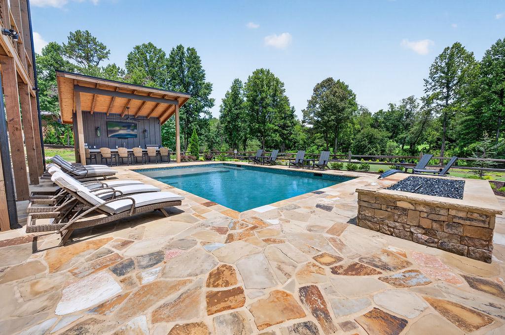 Relax by the private pool with ample lounge chairs and scenic forest views.