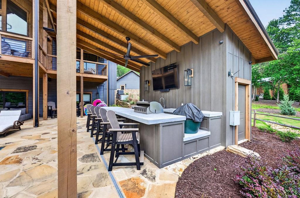Outdoor bar with seating and TV, perfect for entertaining and relaxing evenings.