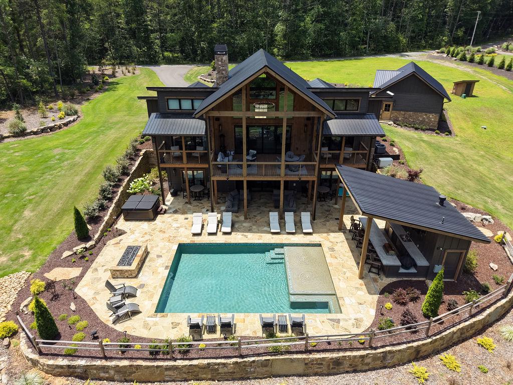 Luxurious outdoor pool area with sun loungers and a covered patio, perfect for relaxation.