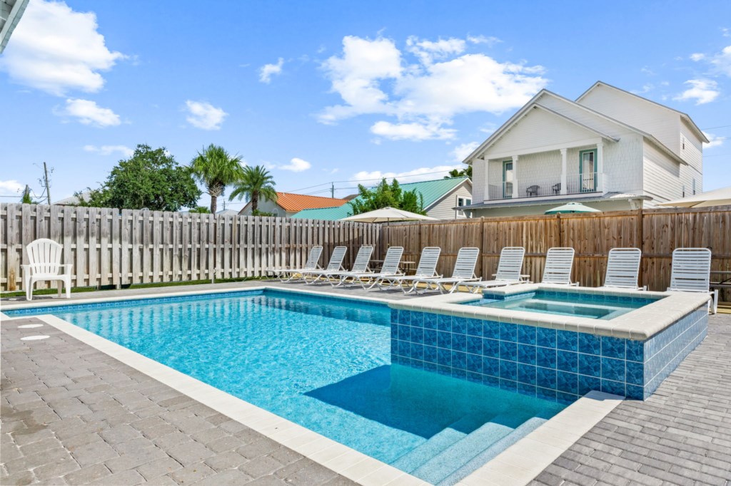 The spacious pool area has a spa and umbrella deck