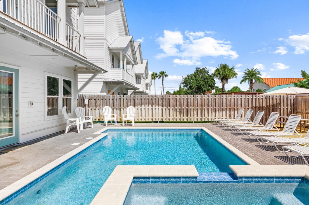 The spacious pool area has a spa and umbrella deck