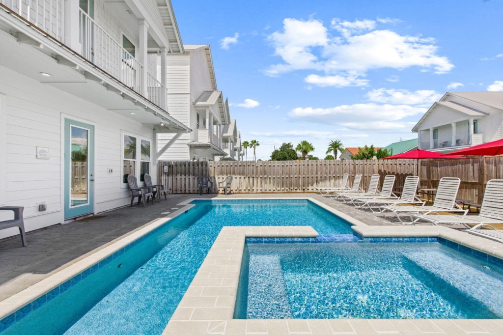 The spacious pool area has a spa and umbrella deck