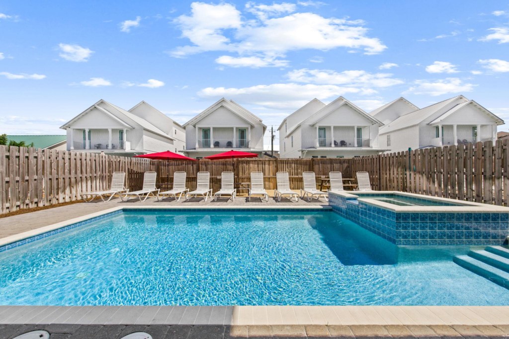 The spacious pool area has a spa and umbrella deck
