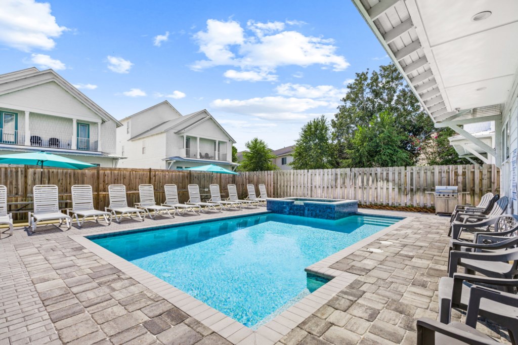 The spacious pool area has a spa and umbrella deck