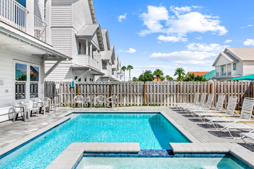 The spacious pool area has a spa and umbrella deck