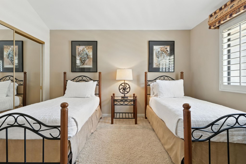 Inviting twin bedroom with elegant decor and natural light, ideal for relaxation.