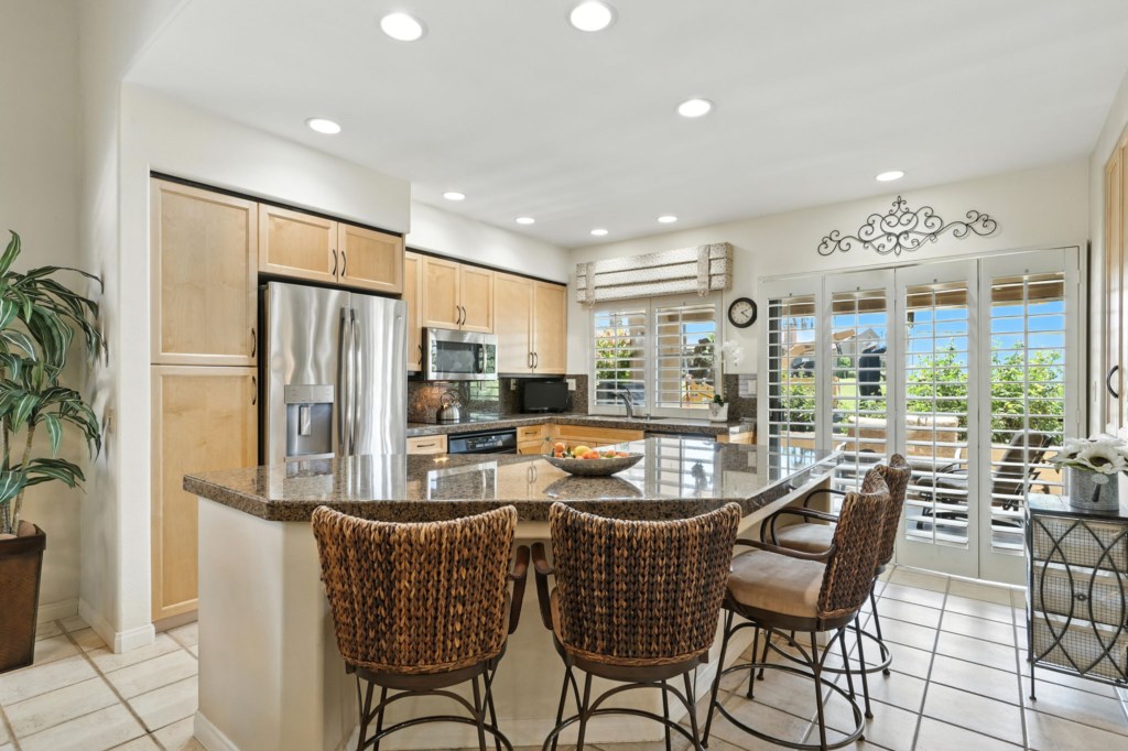 Modern kitchen with stainless steel appliances and a cozy breakfast bar.