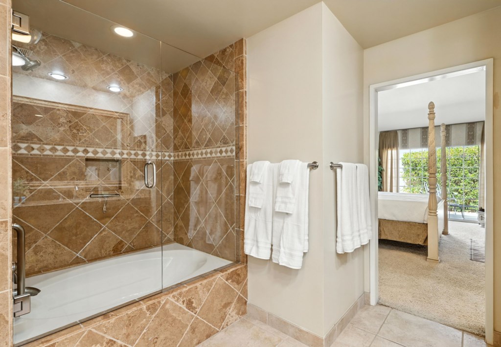 Elegant ensuite bathroom with glass-enclosed shower and direct bedroom access.