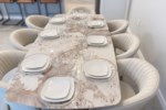 Elegant dining area with a large marble table set for a luxurious meal.