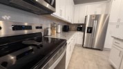 Modern kitchen with stainless steel appliances and granite countertops.